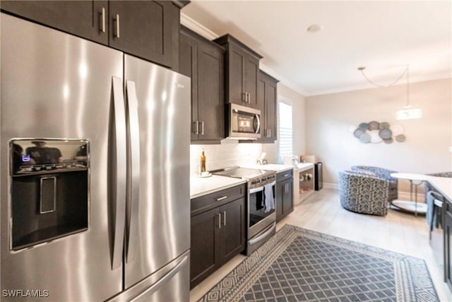 kitchen with crown molding, appliances with stainless steel finishes, dark brown cabinetry, and light hardwood / wood-style floors