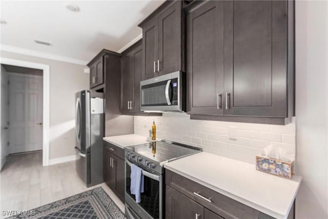 kitchen with tasteful backsplash, dark brown cabinets, light hardwood / wood-style flooring, and appliances with stainless steel finishes