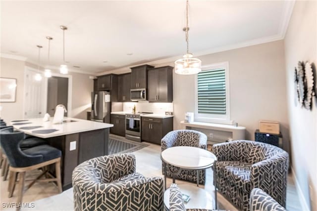 kitchen featuring sink, a breakfast bar area, decorative light fixtures, a center island with sink, and stainless steel appliances