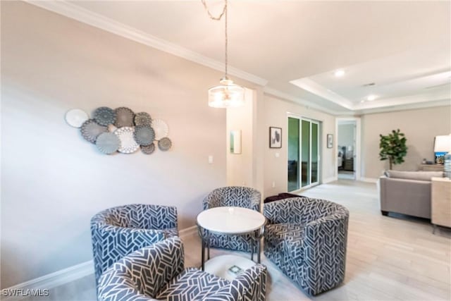 living room featuring hardwood / wood-style flooring, ornamental molding, and a raised ceiling