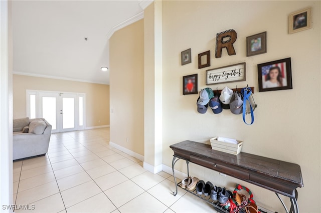 hallway featuring french doors, ornamental molding, and light tile patterned floors