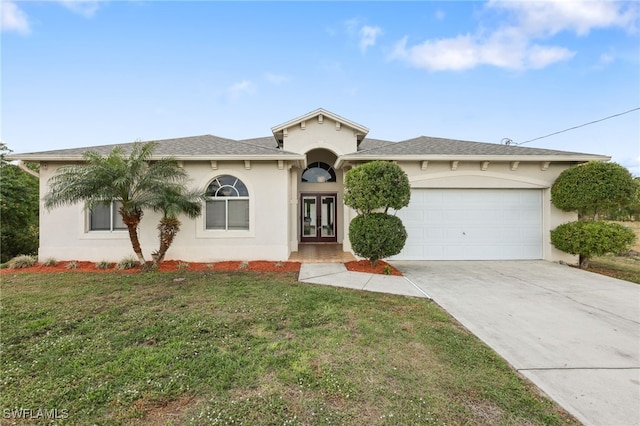 view of front of house with a garage, a front yard, and french doors