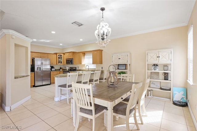 tiled dining room featuring ornamental molding, a chandelier, and sink