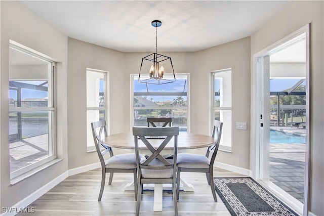 dining space with a notable chandelier and light wood-type flooring