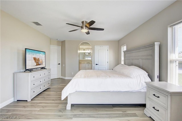 bedroom featuring connected bathroom, light hardwood / wood-style flooring, and ceiling fan