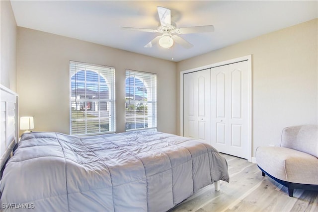 bedroom featuring ceiling fan, a closet, and light wood-type flooring