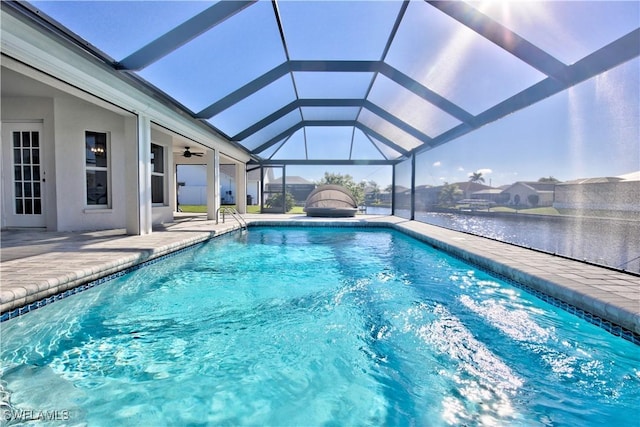 view of pool featuring a water view, ceiling fan, a patio, and glass enclosure