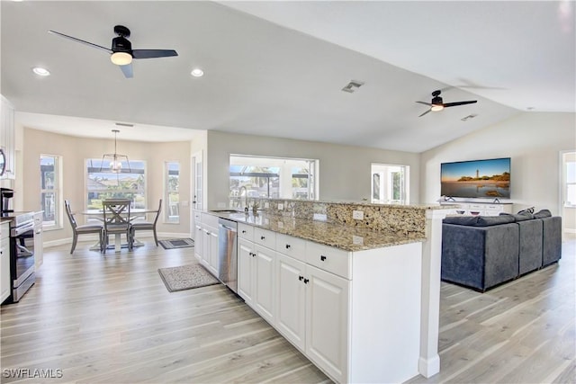 kitchen with pendant lighting, sink, appliances with stainless steel finishes, white cabinetry, and a center island