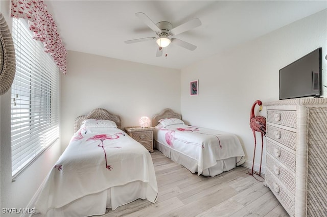 bedroom featuring ceiling fan, light wood-type flooring, and baseboards