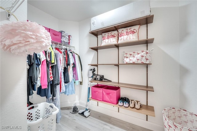 walk in closet with wood finished floors