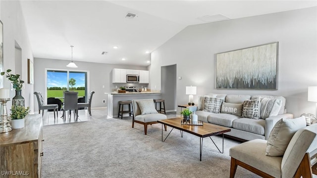 carpeted living room featuring high vaulted ceiling