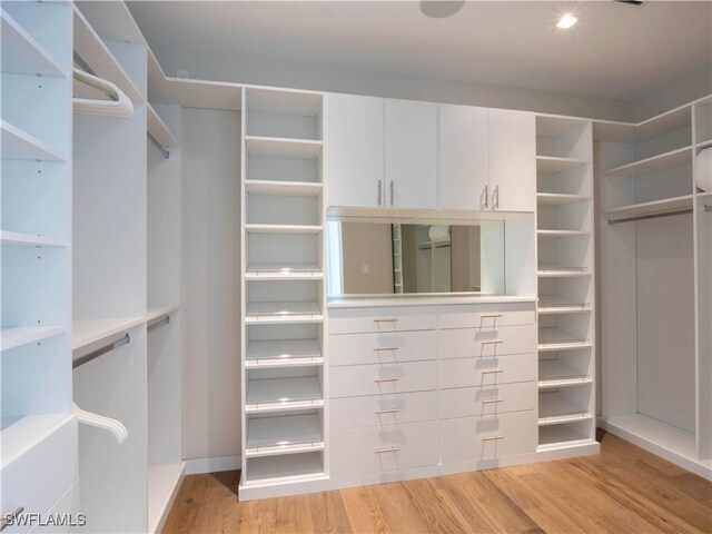 walk in closet with light hardwood / wood-style floors