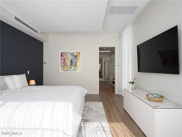 bedroom featuring light wood-type flooring, visible vents, and recessed lighting