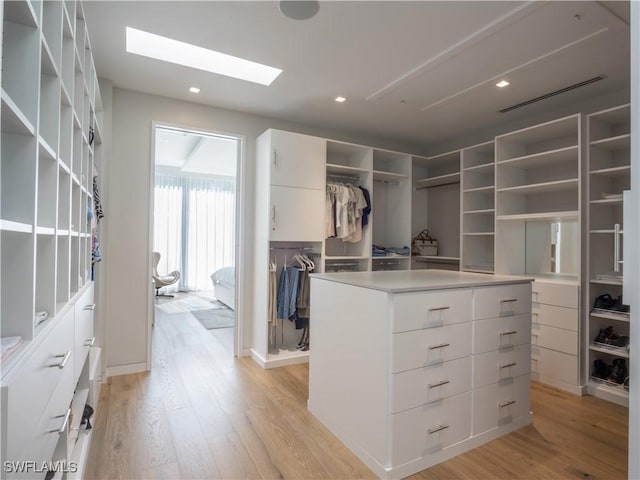 spacious closet featuring a skylight and light wood-type flooring