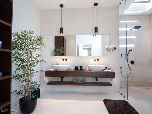 bathroom with a tile shower, vanity, and a skylight