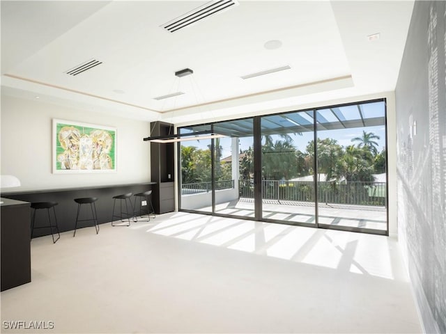 unfurnished living room featuring light colored carpet and a tray ceiling