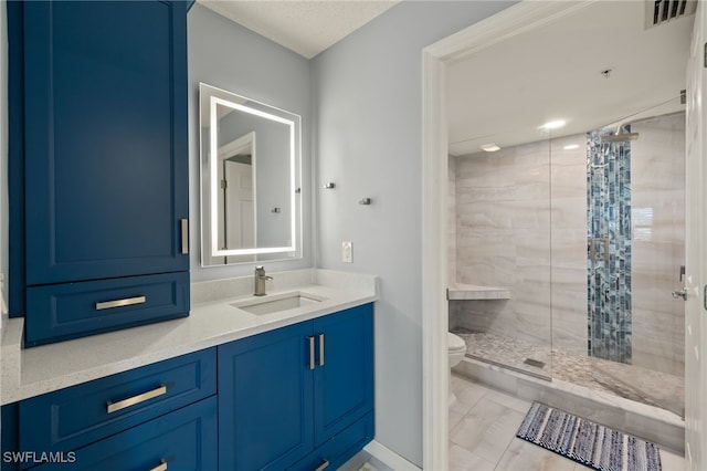 bathroom with vanity, toilet, and a tile shower