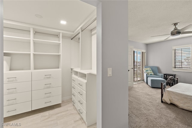 spacious closet featuring light colored carpet and ceiling fan