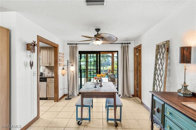 dining space with a ceiling fan, visible vents, a textured ceiling, and light tile patterned floors