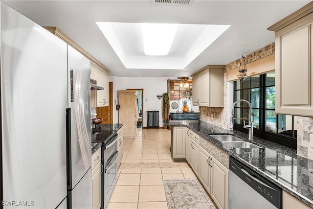 kitchen featuring light tile patterned floors, stainless steel appliances, a sink, radiator heating unit, and a raised ceiling