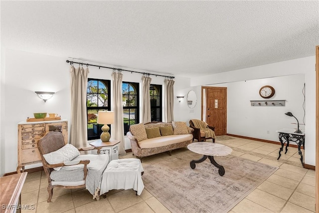 living room featuring a textured ceiling, baseboards, and light tile patterned floors