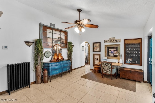 interior space featuring lofted ceiling, light tile patterned floors, ceiling fan, radiator heating unit, and a textured ceiling