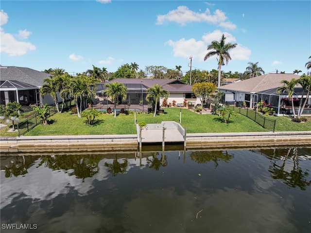 dock area with a water view, a yard, and glass enclosure