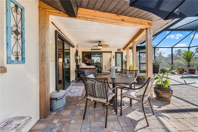 sunroom / solarium featuring ceiling fan and beam ceiling