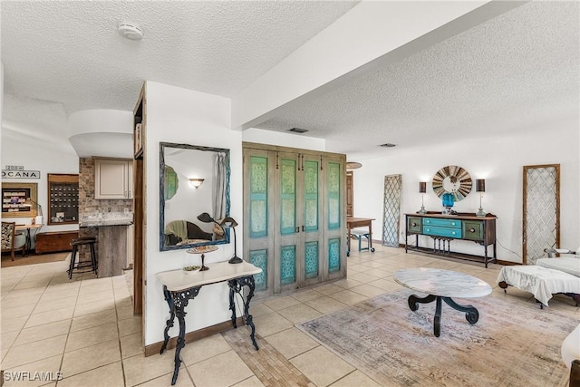 living room with a textured ceiling and light tile patterned floors