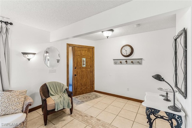 foyer entrance featuring light tile patterned floors, baseboards, and a textured ceiling