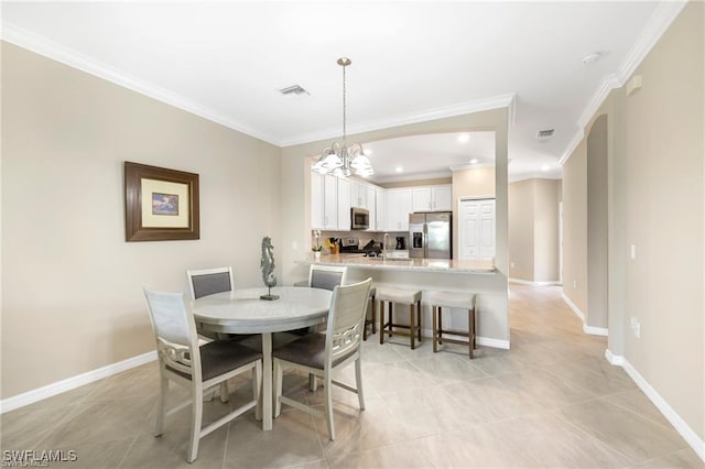 dining room with baseboards, visible vents, a chandelier, and ornamental molding