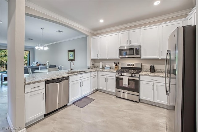 kitchen featuring appliances with stainless steel finishes, a sink, light stone counters, and white cabinets