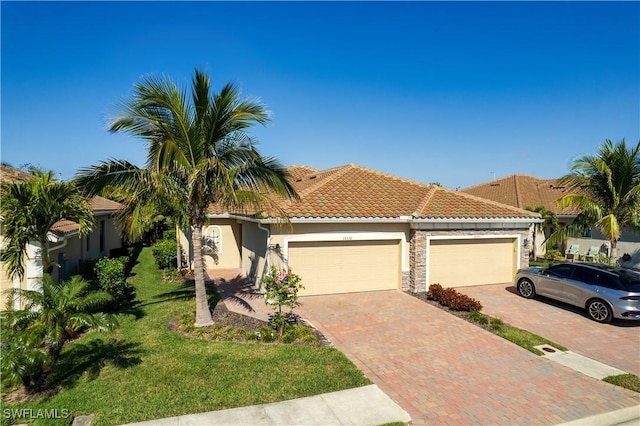 view of front facade with a tiled roof, stone siding, decorative driveway, stucco siding, and a front yard