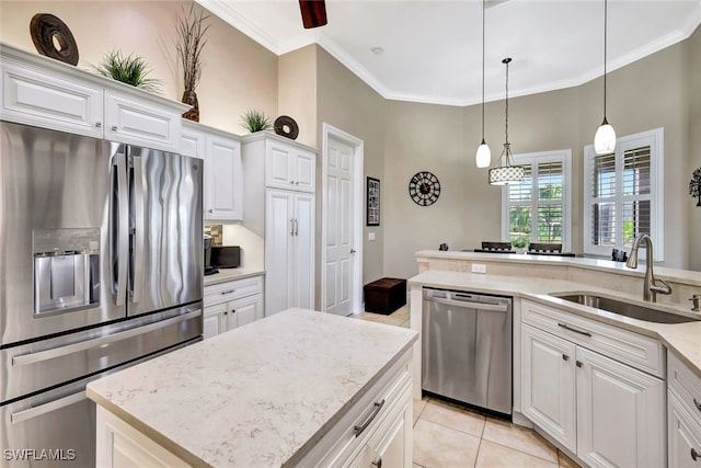 kitchen featuring white cabinetry, sink, hanging light fixtures, ornamental molding, and stainless steel appliances