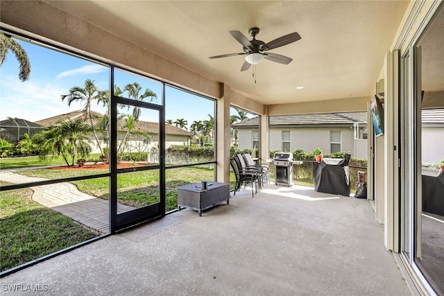 unfurnished sunroom featuring ceiling fan