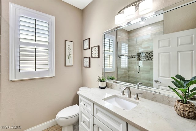 bathroom with vanity, toilet, and a shower with door