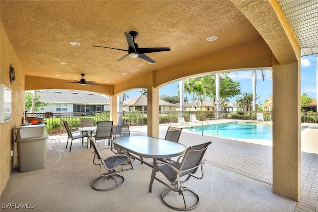 view of swimming pool featuring ceiling fan and a patio area