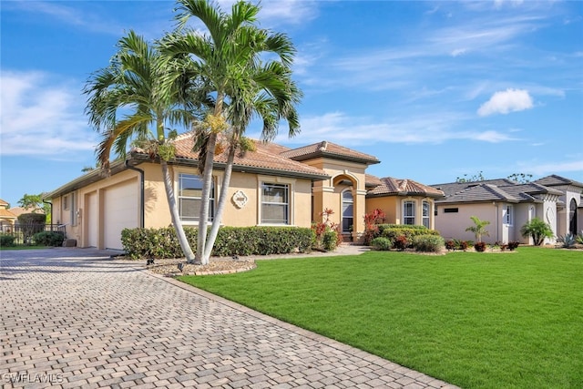 mediterranean / spanish house featuring a garage and a front lawn