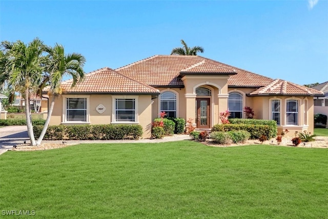 mediterranean / spanish home featuring a front lawn