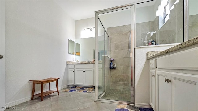 bathroom with vanity, a shower with shower door, and tile patterned floors