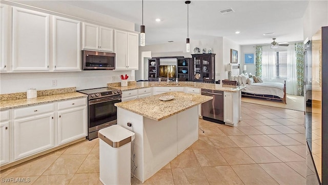 kitchen with a kitchen island, appliances with stainless steel finishes, decorative light fixtures, light tile patterned floors, and kitchen peninsula