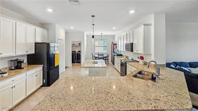 kitchen featuring sink, a center island, kitchen peninsula, pendant lighting, and black appliances