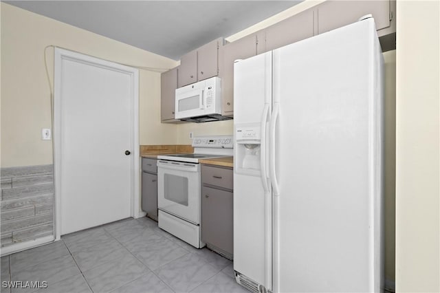 kitchen featuring light tile patterned floors and white appliances