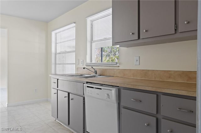 kitchen featuring white dishwasher, sink, and gray cabinetry