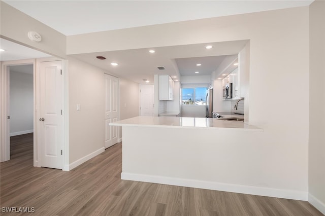 7930 Estero Blvd, Fort Myers Beach, FL 33931 - kitchen with white cabinetry, light wood finished floors, baseboards, a peninsula, and recessed lighting