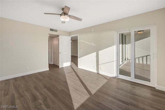 unfurnished room featuring dark wood-style flooring, visible vents, ceiling fan, and baseboards