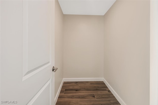 interior space with baseboards and dark wood-type flooring