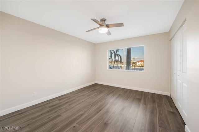 7930 Estero Blvd, Fort Myers Beach, FL 33931 - unfurnished bedroom with a closet, dark wood finished floors, baseboards, and a ceiling fan