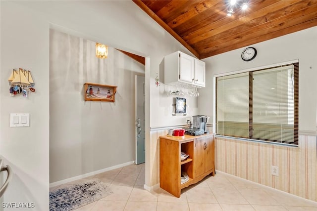 kitchen featuring vaulted ceiling, wooden ceiling, light tile patterned floors, and white cabinets