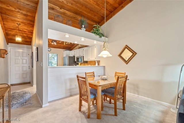 carpeted dining area featuring wooden ceiling and high vaulted ceiling